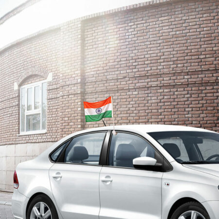 indian flag mounted on cars window with a plastic staff