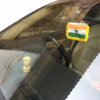 indian flag kept below cars rear view mirror on the windshield with vacuum base