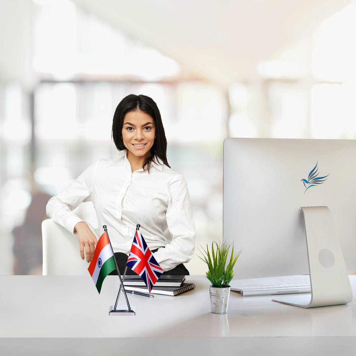 girl sitting at office desk with an indian and uk cross flag chrome plated plastic stand