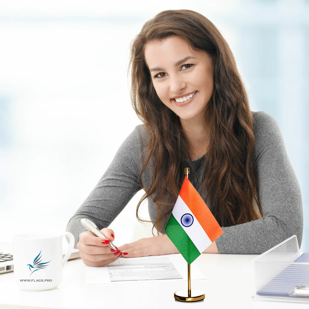 girl sitting at office desk with an indian table flag with a brass stand