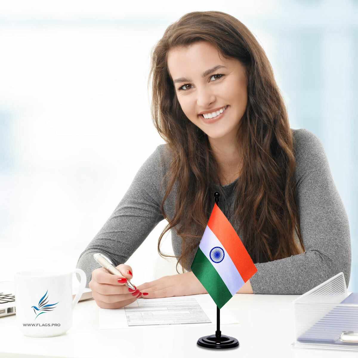 girl sitting at office desk with an indian table flag with a black plastic stand