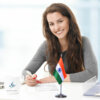 girl sitting at office desk with an indian table flag with a chrome plated plastic stand
